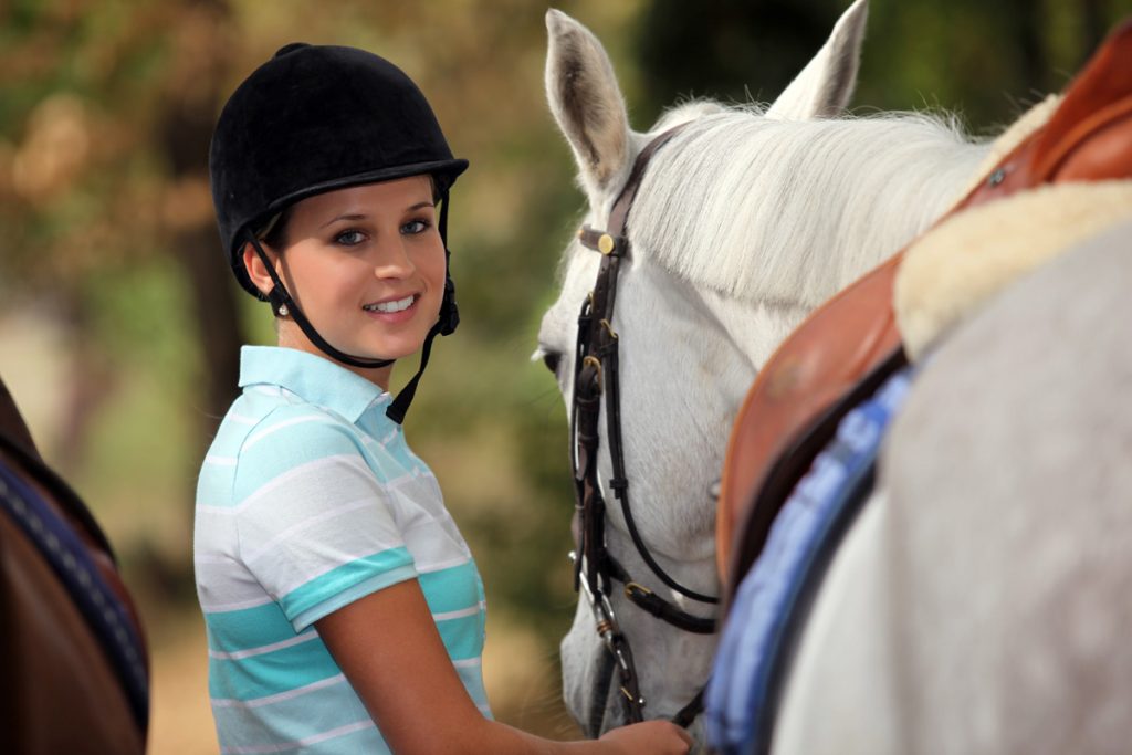 young woman taking care of her horse